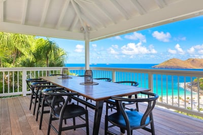 Dining Areas: Outdoor dining area with a rectangular wooden table for eight people. Another dining a