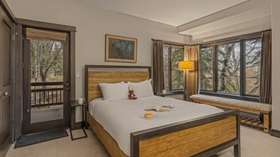 Full bedroom with private balcony, TV, and shared bath on the guest apartment (3rd) level