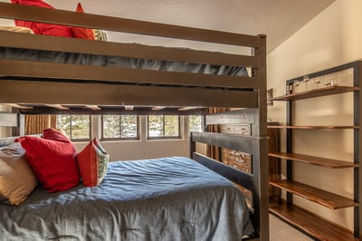 Your cozy bunk bed retreat features soft linens, built-in storage, and peaceful mountain views throu