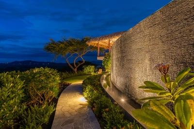 Twilight garden walk lit with soft lights beneath the stars.