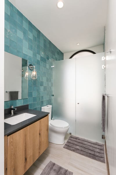 - Clean and calming, this bathroom features glossy green tiles and stylish lighting
- Frosted glass 