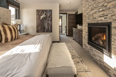 Drift off to sleep beside your own crackling fireplace in this luxurious bedroom retreat with stone 