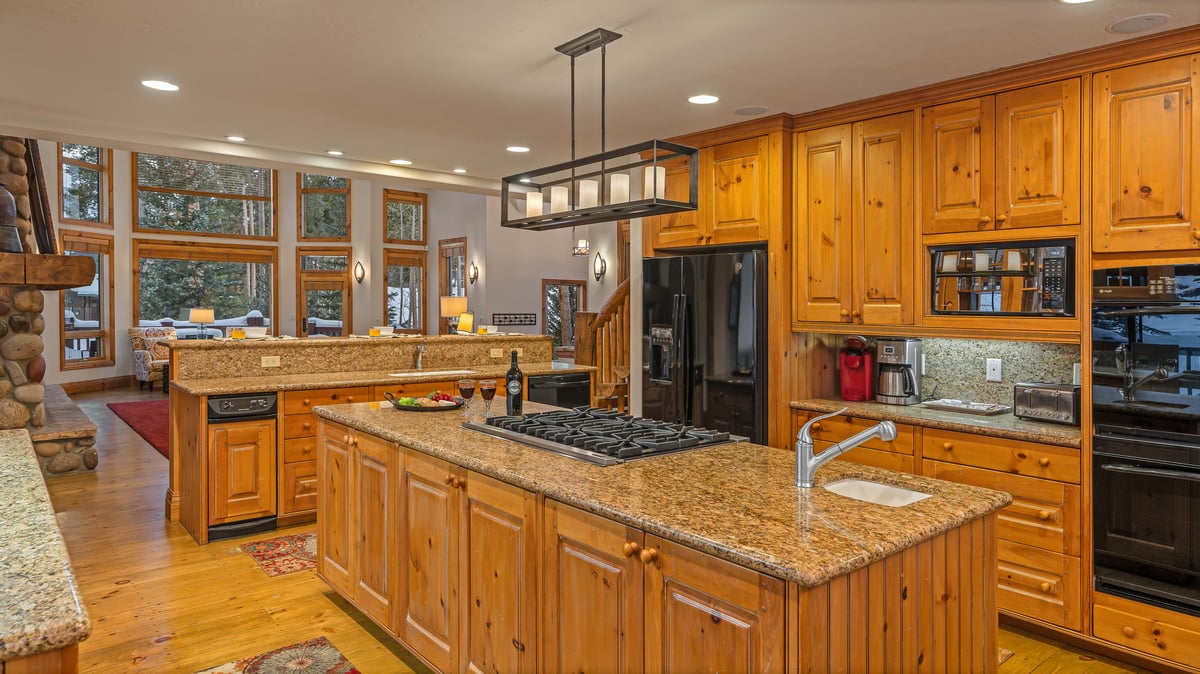 Kitchen features double ovens, gas cooktop, two sinks, and breakfast bar seating - Image 8